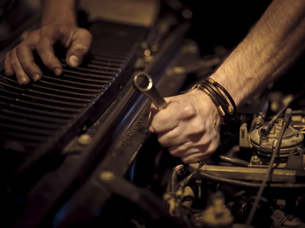 Mechanic repairing a car engine with a wrench